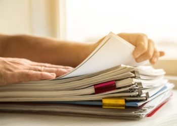 Pilha de documentos sendo organizados