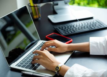 Mão feminina digitando em um notebook